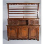 A 19th century French oak dresser, the upper section with three open plate racks above a central