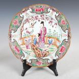 A Chinese porcelain famille rose charger, decorated with mothers and children in a fenced garden