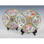 A pair of Chinese porcelain famille rose Canton plates, Qing Dynasty, decorated with panels of