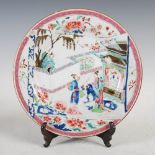 A Chinese famille rose porcelain plate, Qing Dynasty, decorated with a scroll shaped panel enclosing