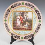 A Vienna porcelain pink ground charger, decorated with a hand painted scene of cupid, male and