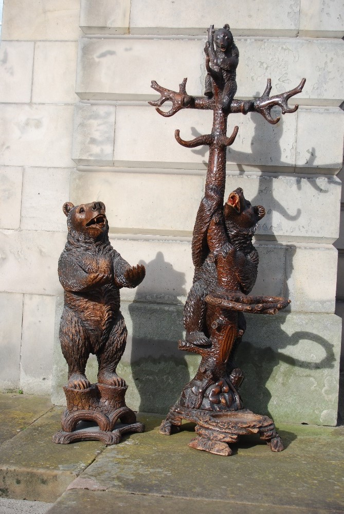 A late 19th/ early 20th century Black Forest carved bear hall stand, carved with a bear holding a