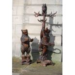 A late 19th/ early 20th century Black Forest carved bear hall stand, carved with a bear holding a