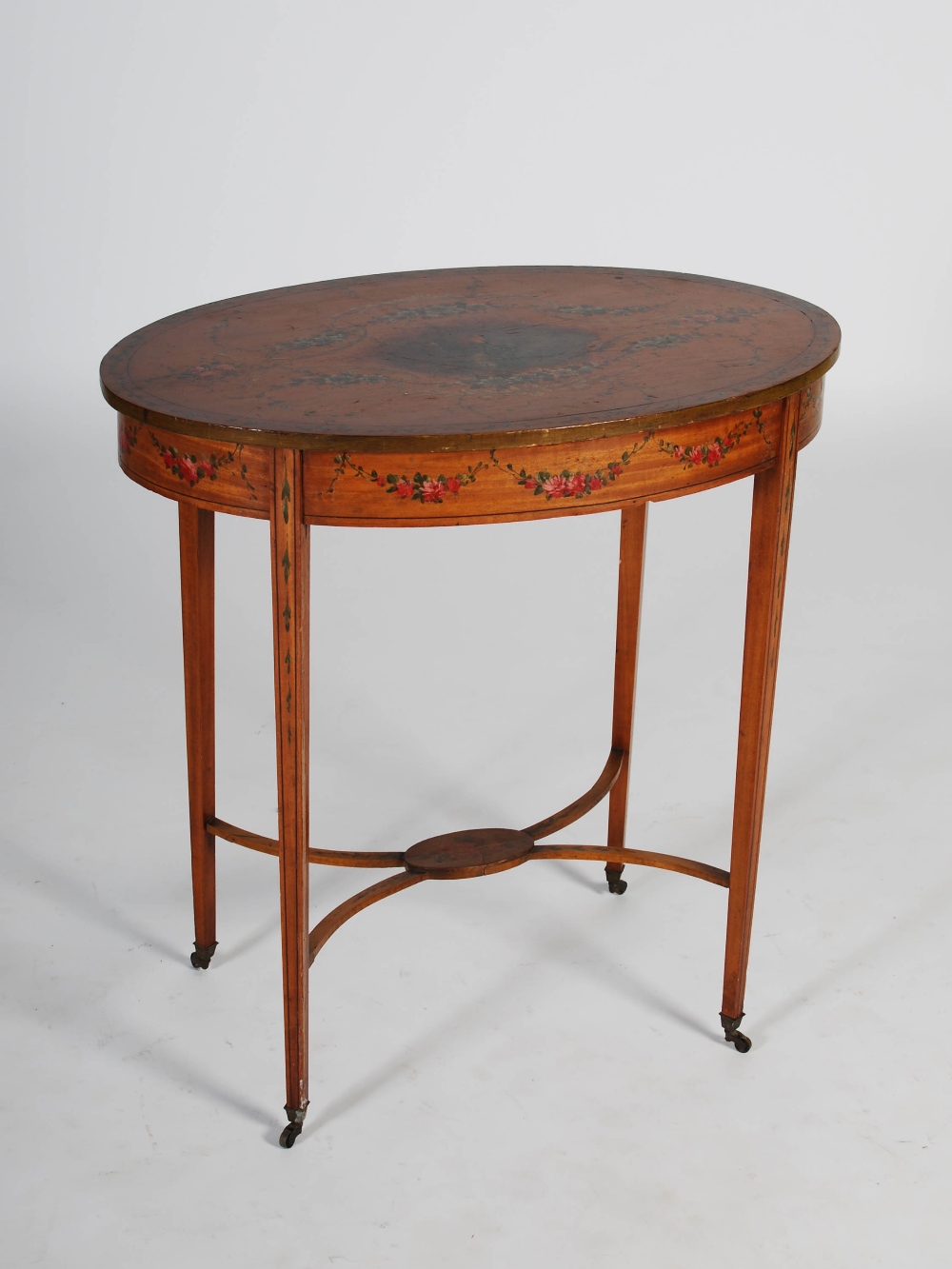 An Edwardian painted satinwood occasional table, the oval shaped top decorated with vignette of a