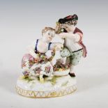 A Continental porcelain figure group, modelled with boy and girl arranging floral garlands, on