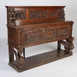 A 19th century oak buffet/serving table, the rectangular panelled back carved with figural and