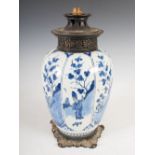 A gilt metal mounted Delft pottery jar, converted to table lamp, the tapered cylindrical body