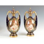 A pair of Royal Vienna cobalt blue ground twin handled porcelain urns and covers with reticulated