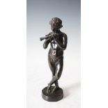 A late 19th century bronze figure of a boy playing the flute after The Antique, on circular plinth