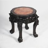 A Chinese dark wood jardiniere stand, Qing Dynasty, the shaped octagonal top with a mottled red