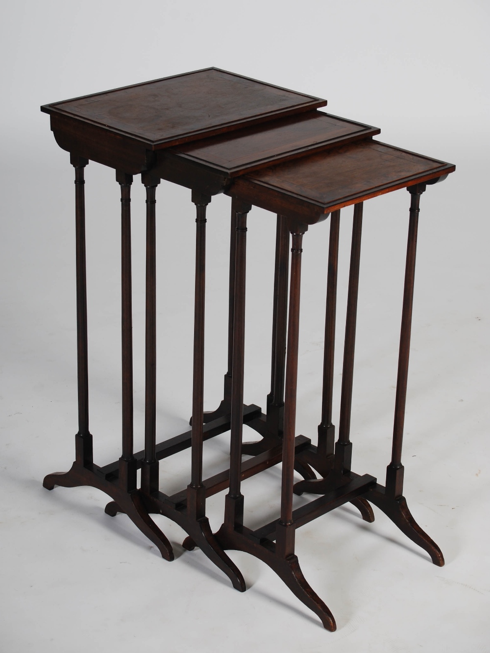 A nest of three 19th century rosewood occasional tables, the rectangular tops with burr wood