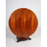 A 19th century rosewood snap top dining table, the hinged circular top raised on a tapered octagonal