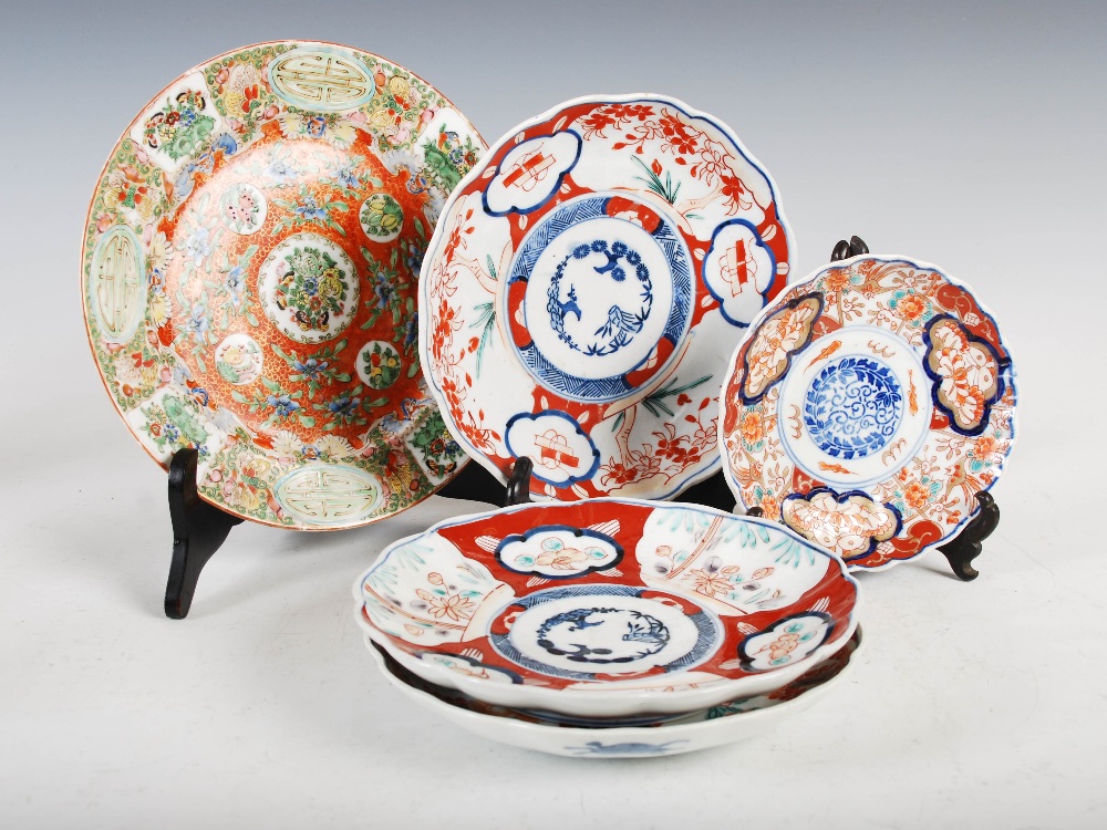 A set of three Japanese Imari plates, decorated with panels of flowers and birds, 21.5cm diameter,