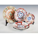 A set of three Japanese Imari plates, decorated with panels of flowers and birds, 21.5cm diameter,