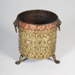 A 19th century copper and brass fuel bin, with embossed scroll and foliate detail, with lion mask
