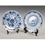 Two 19th century Delft pottery plates, one decorated with foliate spray within feathered border,