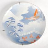 A late 19th/early 20th century Japanese porcelain charger, decorated with pine trees and carp,