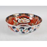 A Japanese Imari bowl, early 20th century, the interior decorated with panels of flowers on a red