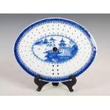 A Chinese porcelain blue and white oval shaped meat plate strainer, pierced and decorated with