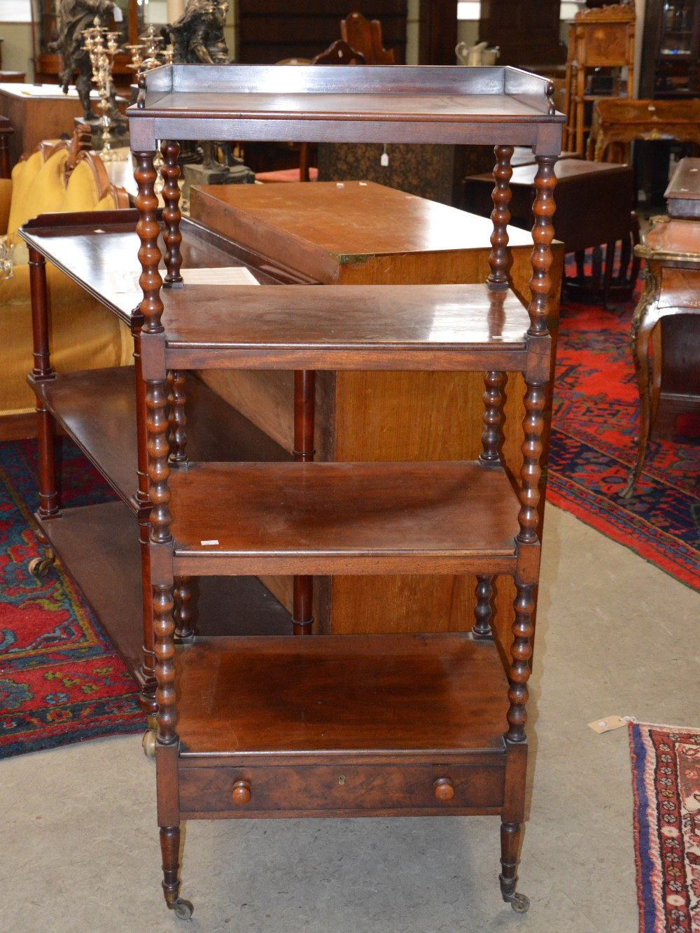 A 19th century mahogany four tier what-not, with single frieze drawer and tapered cylindrical