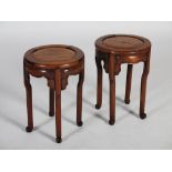 A pair of Chinese dark wood jardiniere stands, late Qing Dynasty, the panelled circular tops above