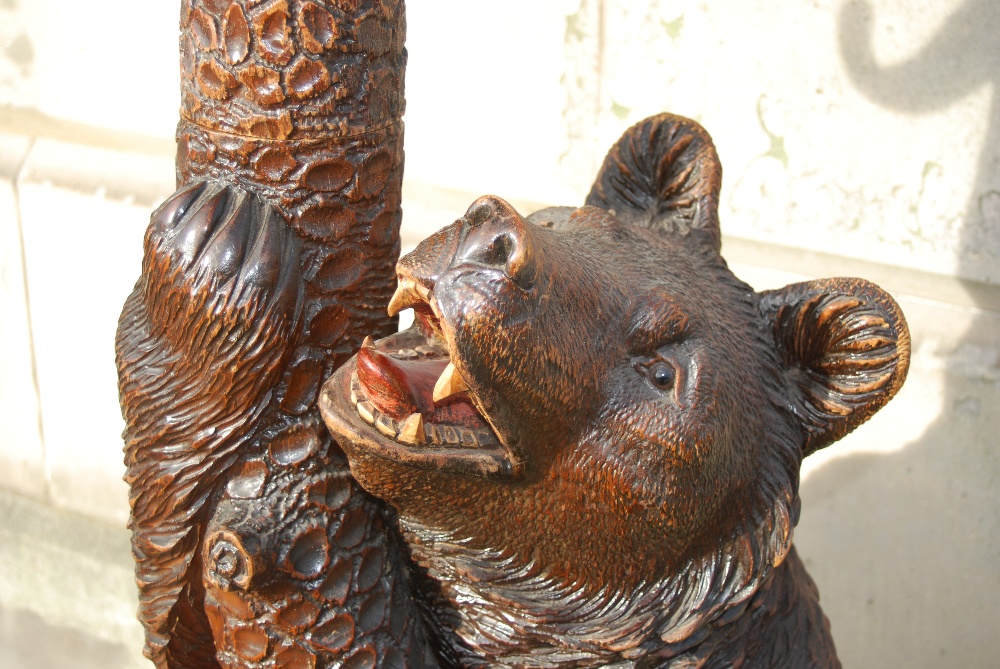 A late 19th/ early 20th century Black Forest carved bear hall stand, carved with a bear holding a - Image 2 of 3