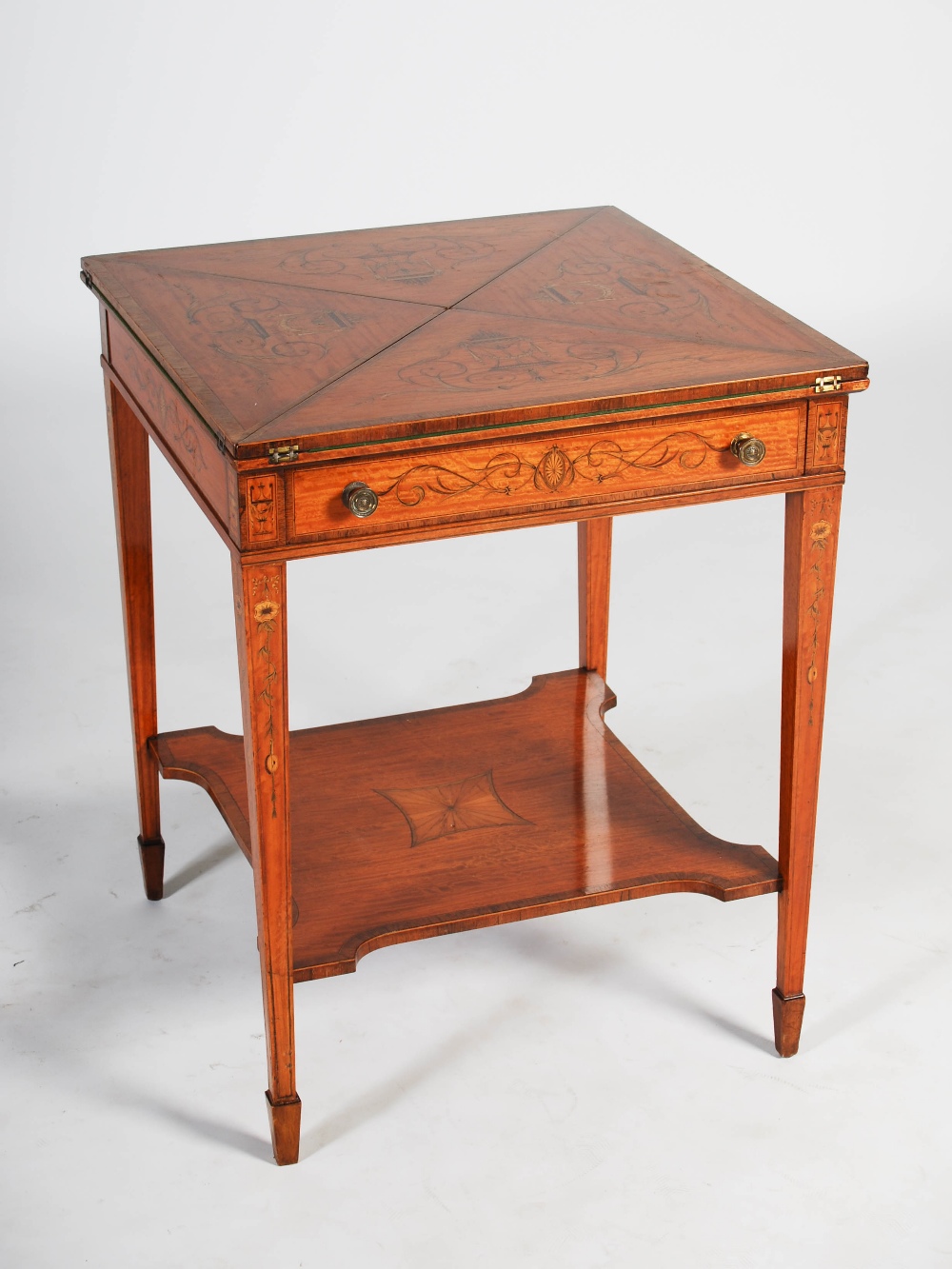 An Edwardian satinwood and marquetry inlaid envelope card table, the square top with four hinged