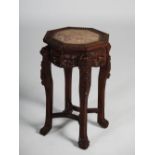 A Chinese dark wood octagonal shaped jardiniere stand, late Qing Dynasty, the top with mottled
