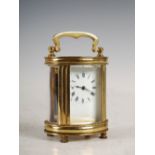 A late 19th/ early 20th century French brass miniature barrel shaped carriage clock, the white