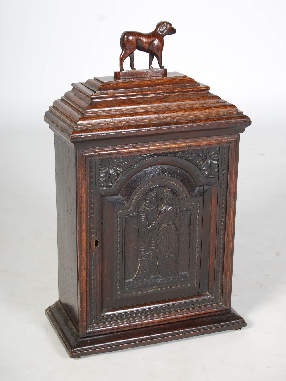 A 19th century oak table cabinet, the caddy top with detachable cover and dog carved finial, over an