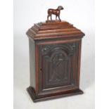 A 19th century oak table cabinet, the caddy top with detachable cover and dog carved finial, over an