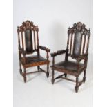 A pair of late Victorian oak armchairs, the top rails carved with shields flanked by lions above