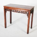 A Chinese dark wood table, Qing Dynasty, the rectangular panelled top above a frieze carved with