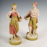 A pair of Royal Dux porcelain figures, the male figure modelled holding a basket of fish in his