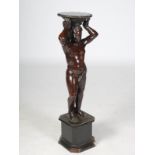 A late 19th century carved and stained wood figural torchere, carved with a semi clad male figure