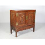 A Chinese dark wood side cabinet, Qing Dynasty, the panelled rectangular top above two panelled