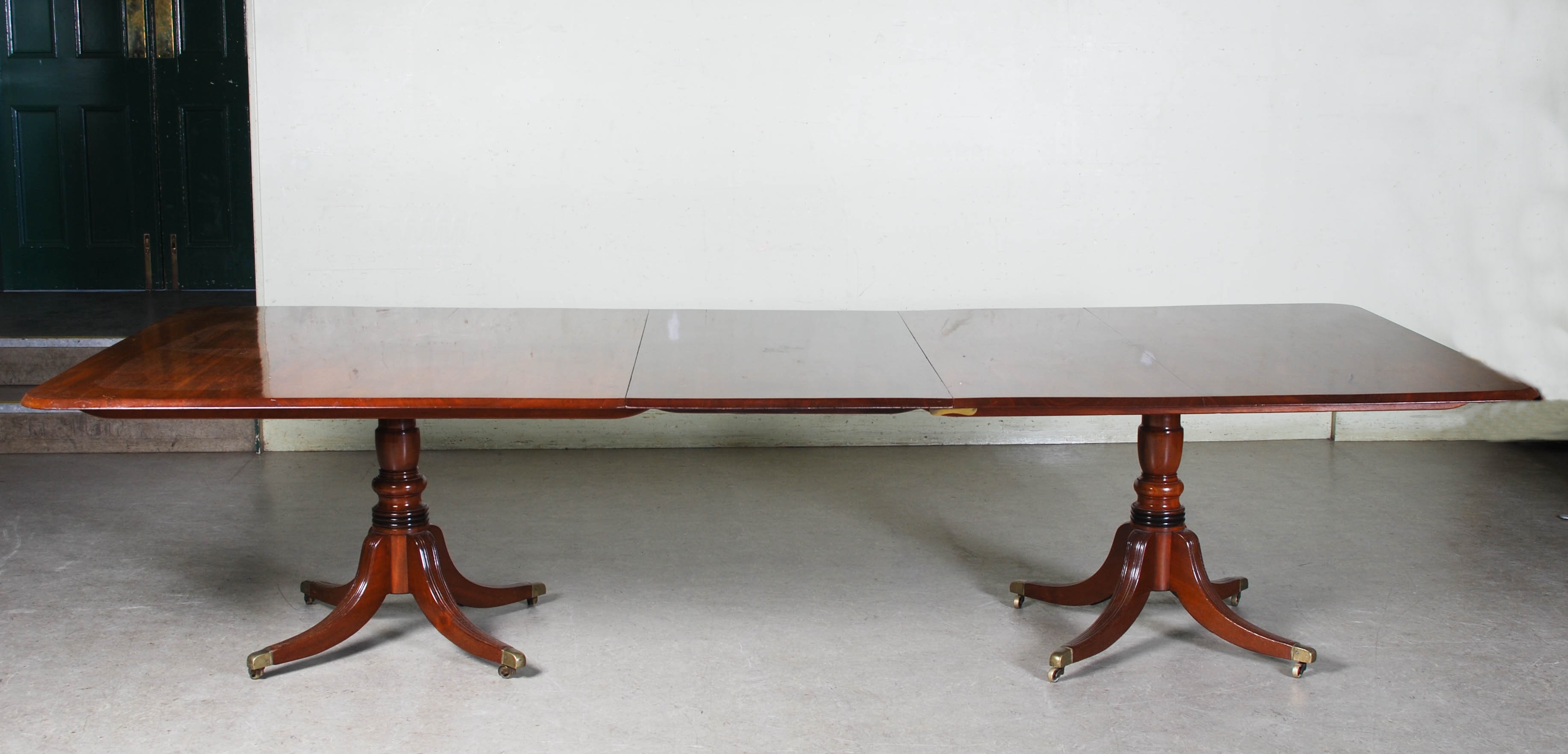 A 19th century mahogany twin pedestal dining table converting to two square snap top pedestal tables