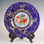 A blue ground opaline glass fruit plate, decorated with a hand painted panel of colourful flowers