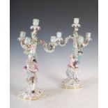 A pair of Meissen porcelain four light candelabra, the flower encrusted branches supporting