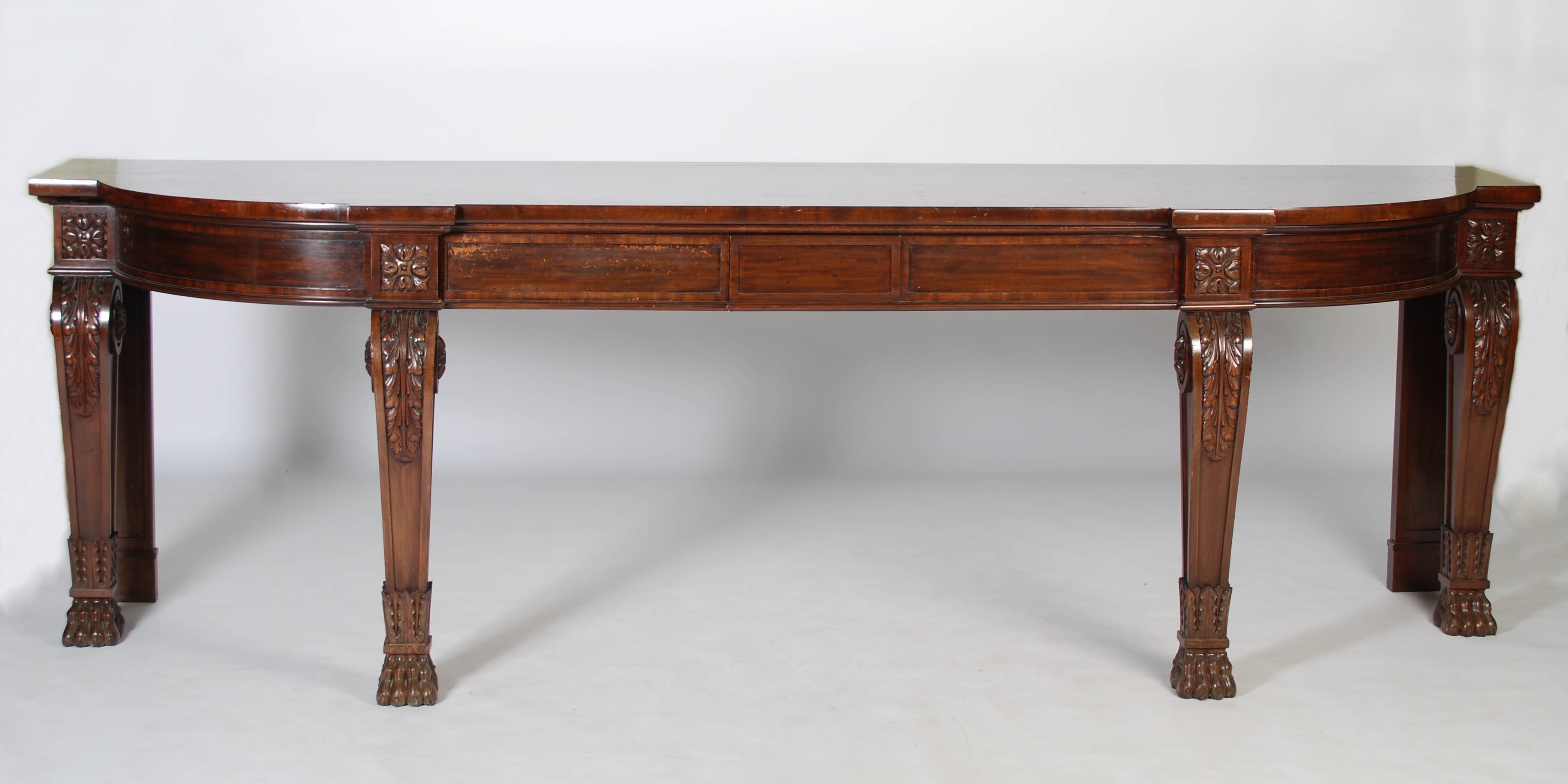 An impressive William IV mahogany serving table, the shaped rectangular top above two blind frieze