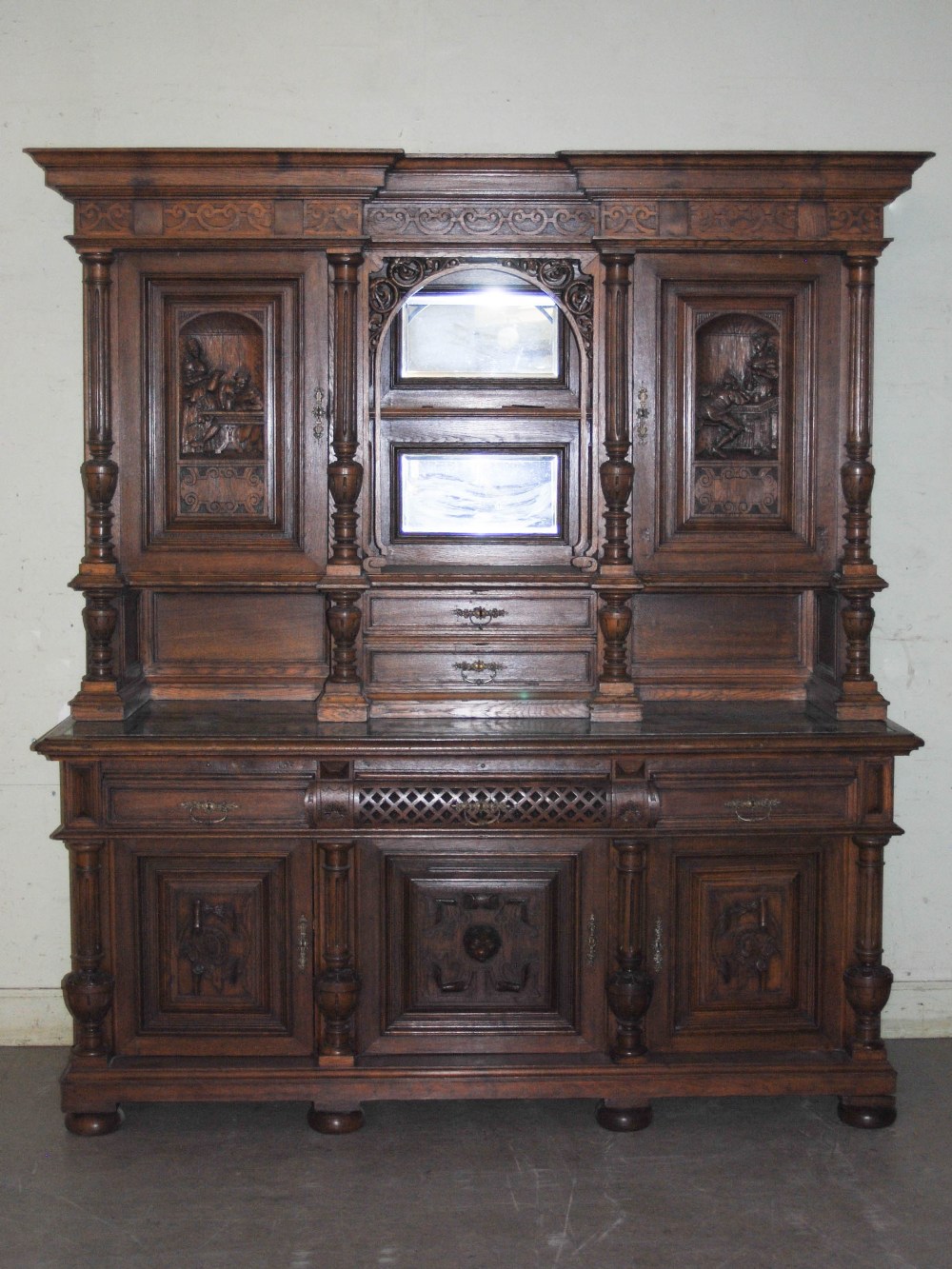 A late 19th century oak sideboard, the upright back with two bevelled mirror recesses and two