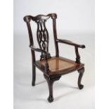 A Chinese dark wood armchair, Qing Dynasty, the shaped top rail above a pierced and interlaced