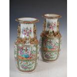 A pair of Chinese porcelain famille rose Canton vases, Qing Dynasty, decorated with panels of