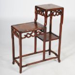 A Chinese dark wood stand, Qing Dynasty, of asymmetric rectangular form, raised on cylindrical