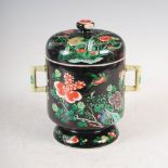 A Chinese porcelain black ground twin handled cup and cover, Qing Dynasty, decorated with peony