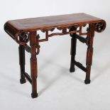 A Chinese dark wood altar table, Qing Dynasty, the rectangular panelled top with convex ends above a