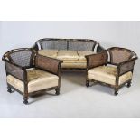 An early 20th century black lacquer chinoiserie decorated three piece Bergere suite, comprising;