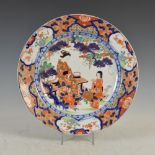 A Japanese Imari charger, Meiji Period, decorated with mother and child in a garden of wisteria