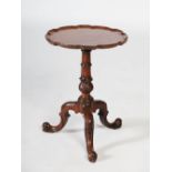 A George III style mahogany tripod occasional table, the circular top with pie crust edge, raised on