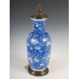 A Chinese porcelain blue and white rouleau vase converted to a table lamp, decorated with prunus